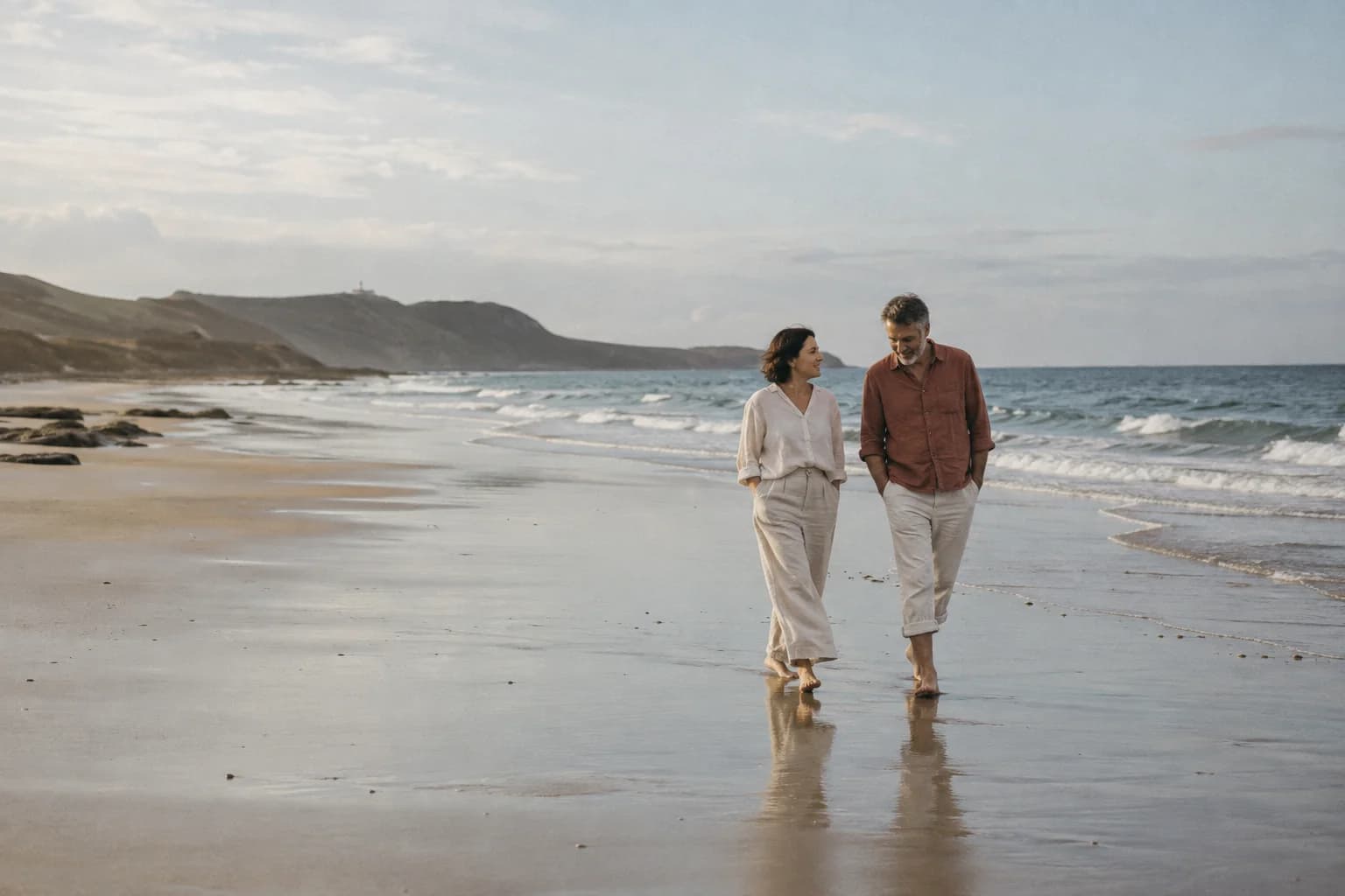 Two people enjoying an unhurried walk beside the ocean